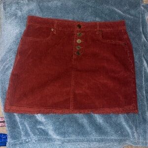 Red/maroon corduroy mini skirt with fringe. Thick material. No stretch. Size:M